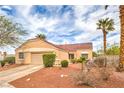 Single-story home with a well-maintained yard, two-car garage, and mature trees, providing curb appeal at 2810 Lava Rock Ave, North Las Vegas, NV 89031