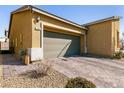 Attractive single-story home featuring a two-car garage with olive green door, brick-paver driveway and desert landscaping at 332 Coldwell Station Rd, North Las Vegas, NV 89084