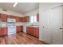 Well-maintained kitchen equipped with wood-look floors, white appliances and wood finished cabinets at 3925 Lazy Pine St # 204, Las Vegas, NV 89108