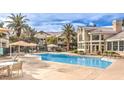 Community pool featuring lounge chairs and dining area with umbrellas, perfect for relaxation and gatherings at 3925 Lazy Pine St # 204, Las Vegas, NV 89108