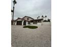 Long front exterior shot of home with neutral color scheme and desert landscaping at 4054 Venita Ct, Las Vegas, NV 89120