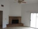 Bright living room featuring a brick fireplace, tiled floors, and sliding glass door to the backyard at 503 Crony Ave, Henderson, NV 89011