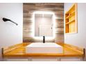 Modern sink and wood accent wall in the bathroom with a lighted square mirror and custom shelves at 5250 S Rainbow Blvd # 2033, Las Vegas, NV 89118