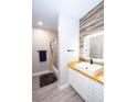Modern bathroom with a wood accent wall, square sink, custom mirror and white vanity at 5250 S Rainbow Blvd # 2033, Las Vegas, NV 89118