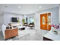 Living room featuring marble floors, modern furniture, and a decorative front door at 60 E Levi Ave, Las Vegas, NV 89183