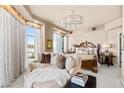 Serene main bedroom with a sitting area, plush bedding, chandelier, and expansive views through large windows at 9103 Alta Dr # 602, Las Vegas, NV 89145