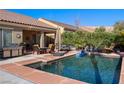 Relaxing backyard pool with outdoor kitchen, dining area, lounge chair, and lush landscaping creates a private oasis at 950 Overland Trl, Mesquite, NV 89034