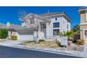 Inviting two-story home with a manicured lawn, a two-car garage, and nearby palm trees at 10216 Via Roma Pl, Las Vegas, NV 89144