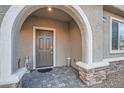 Inviting covered entry features a stone base, neutral paint, and a stylish front door at 1328 Graphite Ave, Henderson, NV 89002