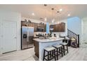 Bright kitchen featuring stainless steel appliances, granite counters, an island, and light wood floors at 1328 Graphite Ave, Henderson, NV 89002