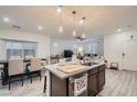Open concept kitchen with island, granite counters, stainless sink, and adjacent dining area at 1328 Graphite Ave, Henderson, NV 89002