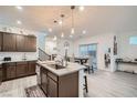 Beautiful kitchen with dark wood cabinets, granite counters, pendant lights, and stainless steel sink at 1328 Graphite Ave, Henderson, NV 89002