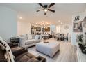 Open-concept living room flows into the kitchen, featuring modern decor and gray wood-look flooring at 1328 Graphite Ave, Henderson, NV 89002