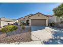 Single-story home features a two-car garage and desert landscaping at 2088 Sawtooth Mountain Dr, Henderson, NV 89044