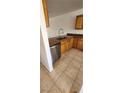 Kitchen with stainless steel appliances and tiled floor with wood cabinets and dark countertops at 510 Holick Ave, Henderson, NV 89011