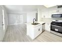 Bright kitchen with white cabinets, stainless steel appliances, and a center island with a sink at 5222 Mandalay Springs Dr # 202, Las Vegas, NV 89120