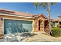 Single Gathering home featuring a charming front entrance, teal garage door, and low maintenance yard at 5292 Cholla Cactus Ave, Las Vegas, NV 89141