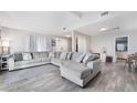 A spacious living room featuring hardwood floors, a large sectional couch, and plenty of natural light at 6320 Vicuna Dr, Las Vegas, NV 89146