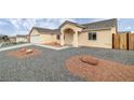 Landscaped front yard featuring rock accents and a charming entrance with an archway and pillars at 672 Lampshire Ln, Pahrump, NV 89060