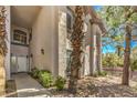 Home's front exterior featuring a walkway, desert landscaping, and arched windows at 104 Breezy Tree Ct # 201, Las Vegas, NV 89145