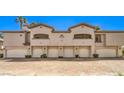 Home exterior featuring multiple garage doors and unit numbers under the balcony windows at 104 Breezy Tree Ct # 201, Las Vegas, NV 89145