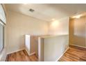 Hallway with hardwood floors, neutral paint, and a staircase with a half-wall at 104 Breezy Tree Ct # 201, Las Vegas, NV 89145