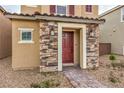 Close up view of the front door with stone accents and stylish exterior lighting at 1115 Brilliant Meadow Ave, North Las Vegas, NV 89086