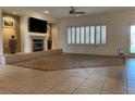 Open living room featuring tiled floors, a fireplace, and a ceiling fan for added comfort at 1654 Danbury Crossing Dr, Henderson, NV 89052