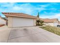 Spacious two-car garage with a wide driveway and desert landscaping in front of the property at 178 Beach Oak Ave, Henderson, NV 89002