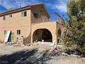 Two story home with an outdoor balcony area, exterior stairs and arched entryway at 1851 Pinto Ln, Pahrump, NV 89060