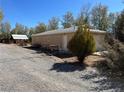 A detached garage with gravel landscaping and adjacent shed, suitable for workshop or storage at 1851 Pinto Ln, Pahrump, NV 89060