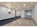 Well-maintained condo hallway featuring an elevator and unit directional signage at 19 E Agate Ave # 402, Las Vegas, NV 89123