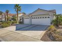 Attractive home boasts a large driveway leading to a three-car garage and a well-cared-for lawn at 2012 Lady Lake St, Las Vegas, NV 89128