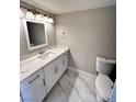 Well-lit bathroom features a modern vanity with quartz countertop and stylish marble floors at 2428 Greens Ave, Henderson, NV 89014