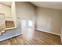 Open-concept living room featuring stairs, wood floors, and neutral paint throughout the home at 2428 Greens Ave, Henderson, NV 89014