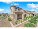 Attractive townhome featuring a quaint, covered patio, landscaped yard and inviting entrance at 2449 Padulle Pl, Henderson, NV 89044
