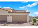 Attached two-car garage with brick driveway and desert landscaping at 2449 Padulle Pl, Henderson, NV 89044