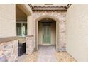 Inviting front entryway with stone details, arched doorframe, and a paved walkway at 2871 Cabrillo Terrace St, Henderson, NV 89044