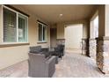 Covered patio with stone pillars and neutral tones, complete with wicker seating and decor at 2871 Cabrillo Terrace St, Henderson, NV 89044