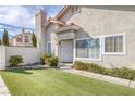 Inviting front entrance with a white door, artificial lawn and well-maintained landscaping at 301 Montcliff Ave, Henderson, NV 89074