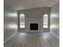 Inviting living room featuring a fireplace, arched windows, and stylish gray flooring at 325 Greenfield Ln, Las Vegas, NV 89107