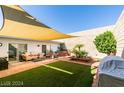 Relaxing backyard patio area featuring ample seating, a hot tub, and artificial turf at 3727 Centennial Cir, Las Vegas, NV 89121