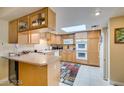 Functional kitchen with skylight, bar seating, and plentiful counter and cabinet space at 3727 Centennial Cir, Las Vegas, NV 89121