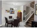 Dining room with a glass table, neutral paint, and a carpeted staircase at 3844 Hollycroft Dr, North Las Vegas, NV 89081