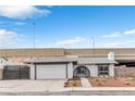 Inviting home exterior with a two-car garage, small garden, and unique arched entrance, perfect for curb appeal at 3911 Chutney St, Las Vegas, NV 89121