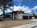Charming single Gathering home with a two car garage, mature tree, and beautiful blue sky at 4417 De Forest St, Las Vegas, NV 89103