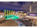 Inviting backyard pool area featuring a pergola, outdoor fireplace, lush landscaping, and comfortable lounge seating at 4752 Rancho Camino Ct, Las Vegas, NV 89129