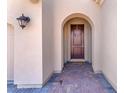 Inviting entryway with a decorative wreath, arched entryway and a brick walkway at 505 Punto Vallata Dr, Henderson, NV 89011