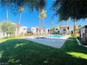 Community pool area with palm trees, manicured grass and multiple residential buildings at 5117 Eldora Ave # 4, Las Vegas, NV 89146