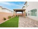 Backyard featuring a gazebo on a brick patio next to a patch of artifical grass at 5384 Knitmore Ct, Las Vegas, NV 89139